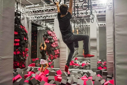 Jumpyard trampolinpark i Helsingborg och deras Ninja Warrior bana. Ett barn hänger i ringarna.