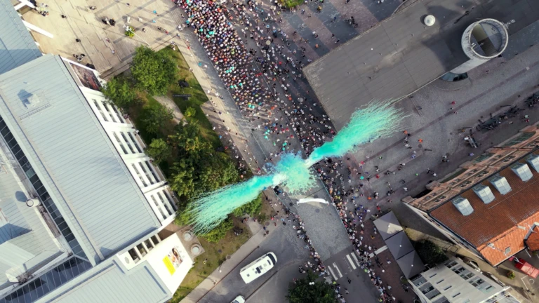 drönarbild över starten av Helsingborg Marathon med grönt fyrverkeri